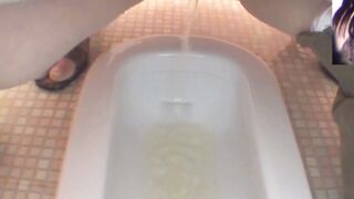 Japanese pair squat and spray golden streams together in the restroom