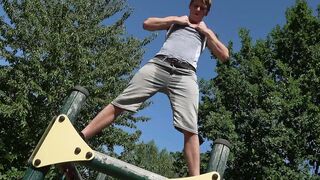 Muscular blond twink workouts on playground pull-up bars and shows his dick