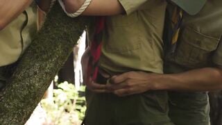 Scout boy bound up against a tree inside the woods by 2 mature scout boys