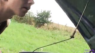 An elderly gentleman view a young women inside trouble with her vehicle