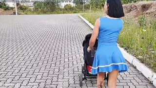 Delightful mother inside blue dress without underwear during street walk.