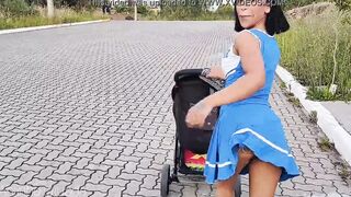 Delightful mother inside blue dress without underwear during street walk.